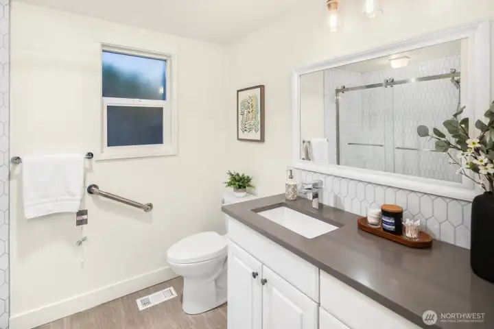 The primary suite features a custom closet system and en-suite bath with an oversized, beautifully tiled shower.