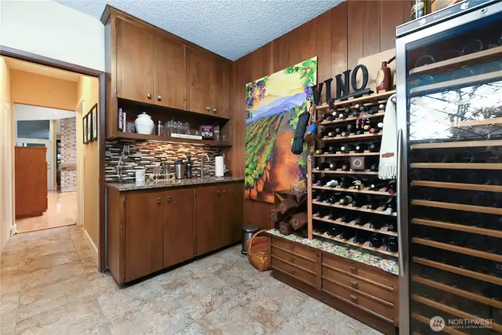 Complete with a dedicated wine room and an adjacent wet bar for effortless entertaining.