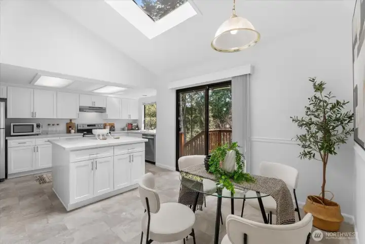 Bright kitchen with center Island, casual dining area, & skylight opens to the deck—perfect for gatherings!