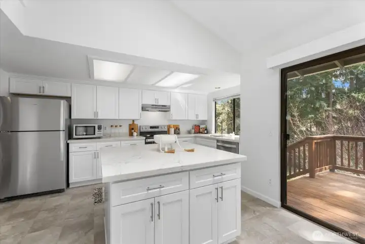 Bright kitchen with center Island, casual dining area, & skylight opens to the deck—perfect for gatherings!