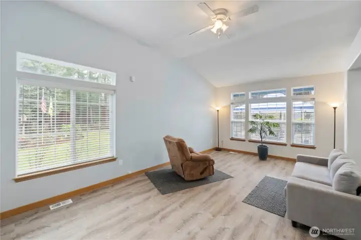 Bright living room with vaulted ceilings, large windows, and abundant natural light.