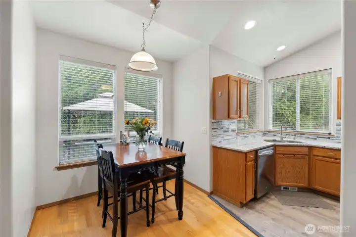 Dining area with large windows bringing in natural light, conveniently located next to the kitchen.