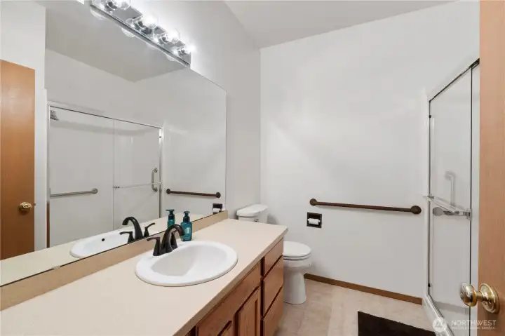 Spacious bathroom featuring a large vanity, walk-in shower with glass door, and clean, bright finishes.