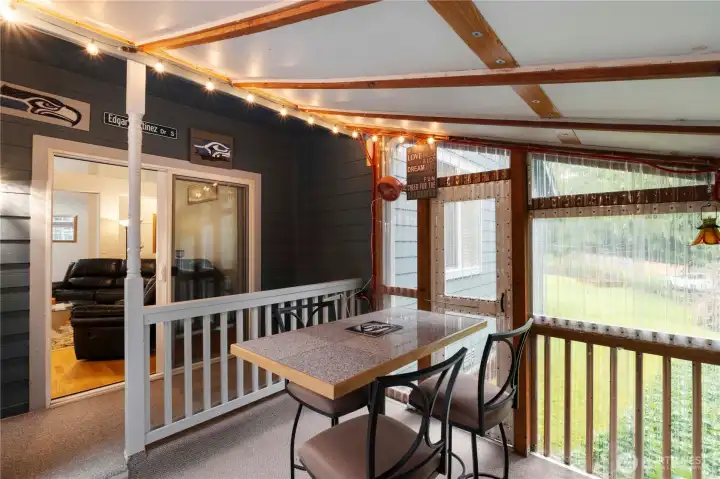 Inviting covered deck space ideal for outdoor dining while enjoying the surrounding greenery.