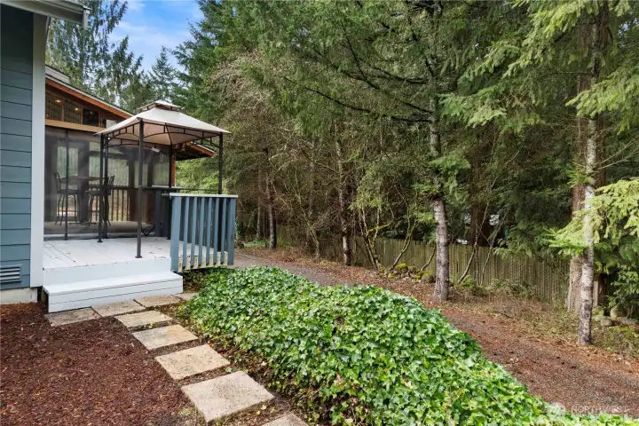 Private backyard setting with deck and gazebo, surrounded by mature trees for a peaceful outdoor retreat.