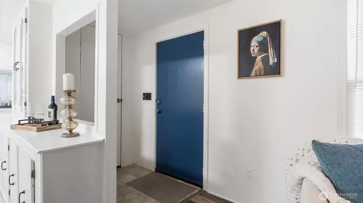 The front door is a cheerful blue color with a coat closet right next to it