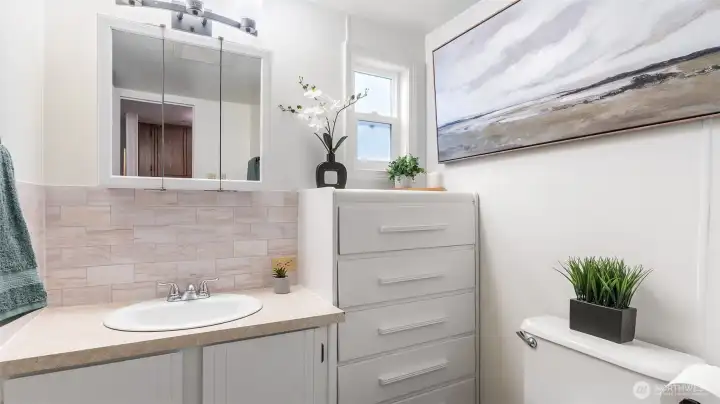 Bathroom with new tile backsplash, lighting and updated toilet