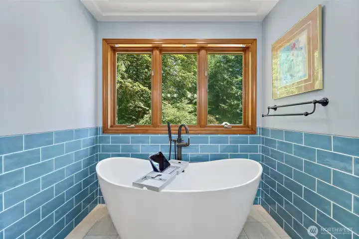 Grand soaking tub overlooks private backyard.