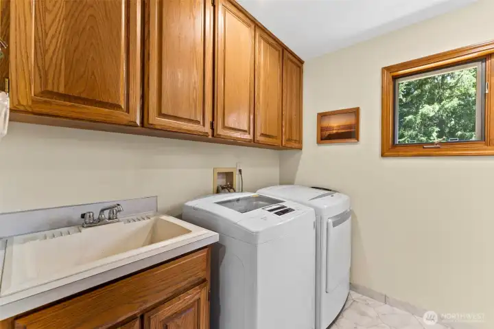 Spacious utility room with mop sink and lots of storage.