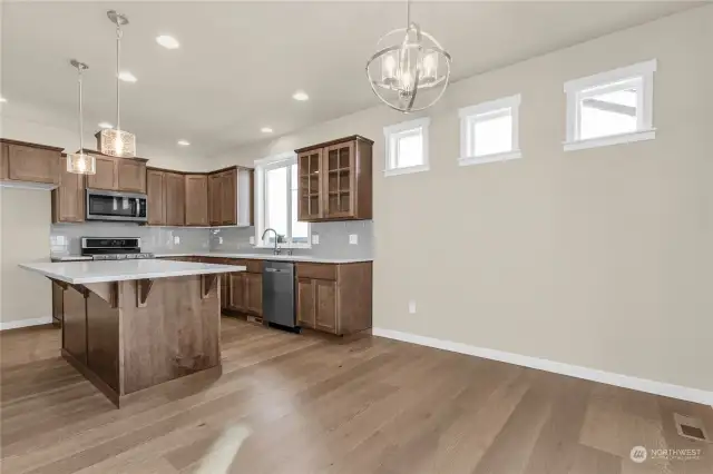 An abundance of light from the overhead can lights, pendant and dining fixtures as well as the accent windows. Photo from same plan on different lot, finishes and features will vary.