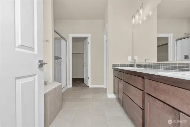 Primary bath features tile flooring and tub surround with private water closet.Photo from same plan on different lot, finishes and features will vary.