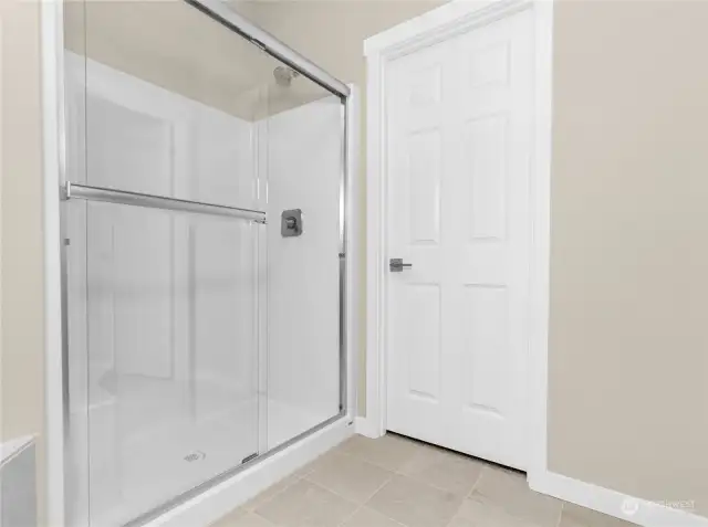 Oversize shower with glass doors and built in seat. Photo from same plan on different lot, finishes and features will vary.