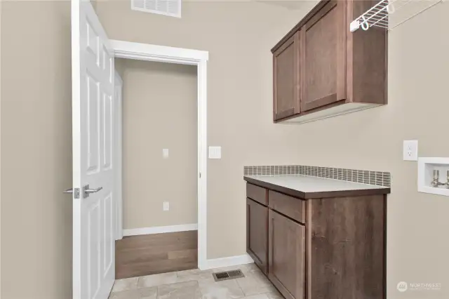 Laundry room includes storage cabinets and built in shelving. Photo from same plan on different lot, finishes and features will vary.