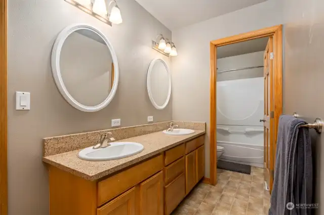 Jack and jill bath with dual vanity and shower separated.