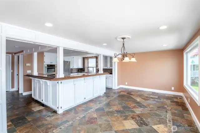 Dining room and kitchen with glimmering slate tile floors