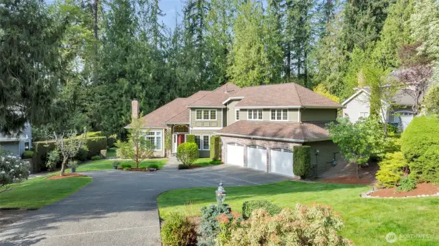 Manicured front yard and spacious and elegant driveway leading to a generous 3-car garage.