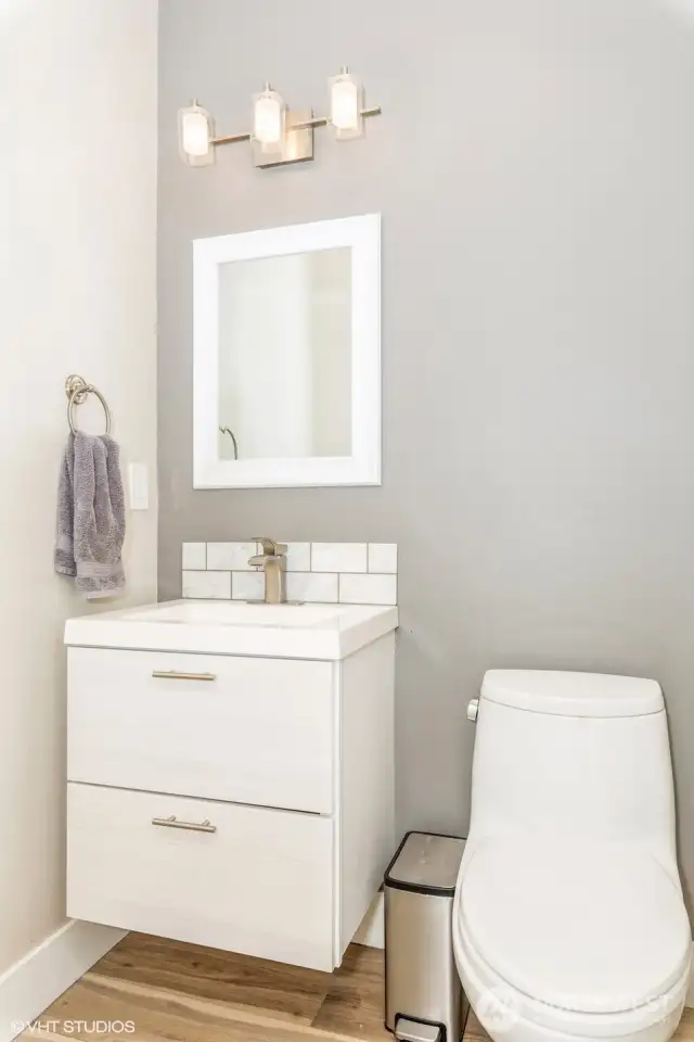 Conveniently located on the main floor, this elegant powder room features a modern vanity, updated fixtures, and neutral tones.