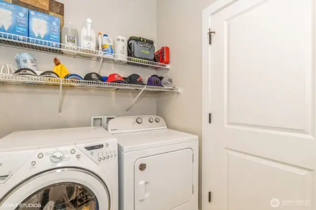 "Laundry room with built-in shelving and space for folding or storage."