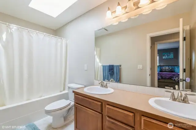 Enjoy a bright and airy feel in this bathroom featuring a skylight that brings in natural light throughout the day—creating a spa-like atmosphere.