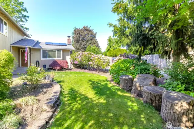 The front yard has lush landscape and spaces for relaxing in privacy