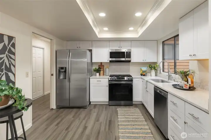 Brand new white shaker cabinetry, recessed lighting, and quartz countertops gives this kitchen an updated style.
