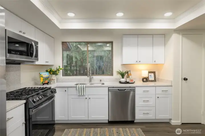 Stainless steel appliances include a gas stove and brand new microwave - check out that beautiful undermounted sink as well.