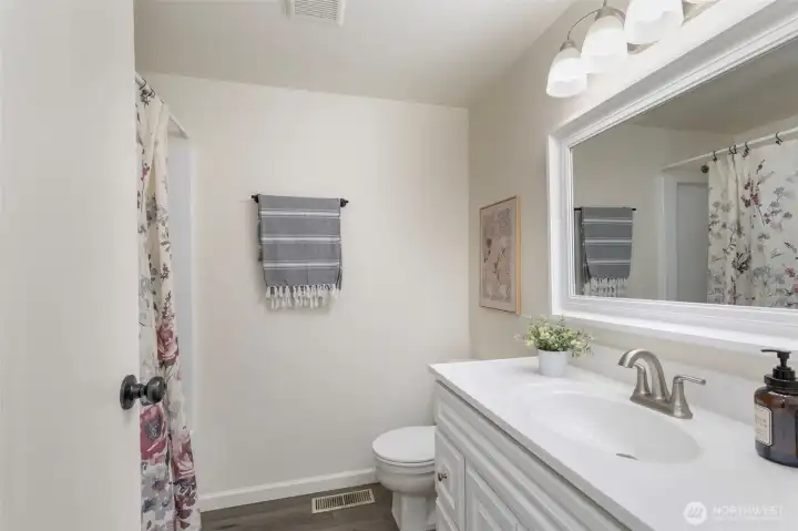 As you work your way down the hall, the updated full guest bathroom.