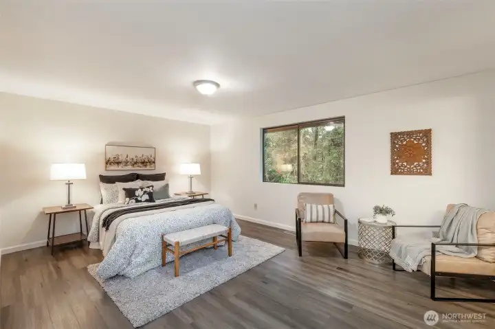 Find the primary bedroom that looks out into the peaceful backyard.