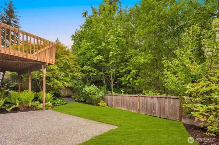 Large patio in the fenced backyard that looks out onto greenspace.