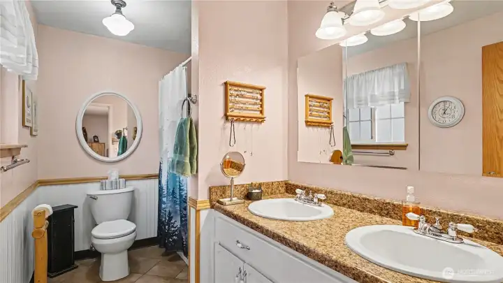 3/4 en-suite bathroom offers dual sinks and ample storage space.