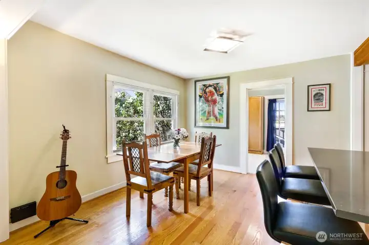 Nice sized dining room with kitchen breakfast bar to the right. Entry to main floor bedroom/office in the background.