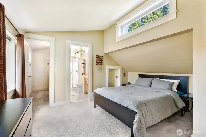 Primary suite is quite large for this size of a home. High ceilings, a walk-in closet to the left, primary bath in the background and a storage closet just on the other side of the bed.