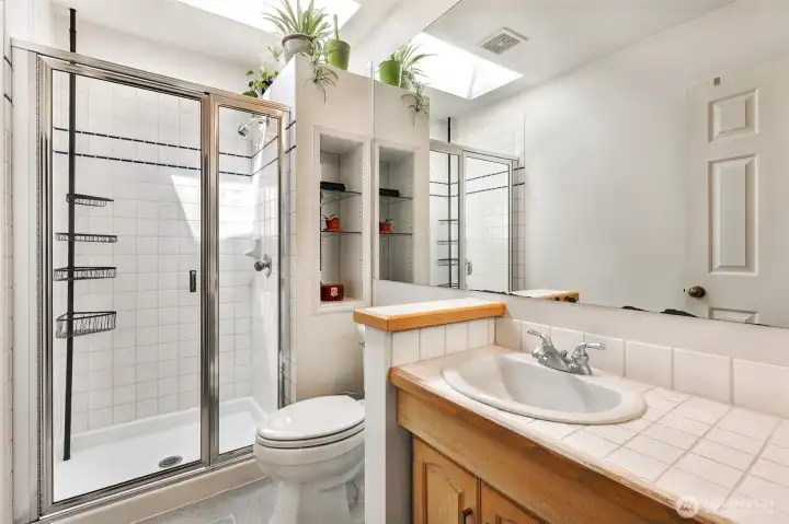 Primary 3/4 bathroom with skylight.