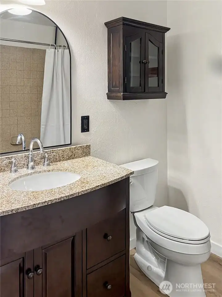 New bathroom vanity, arched mirror, faucet, & shelving for a clean & functional design!