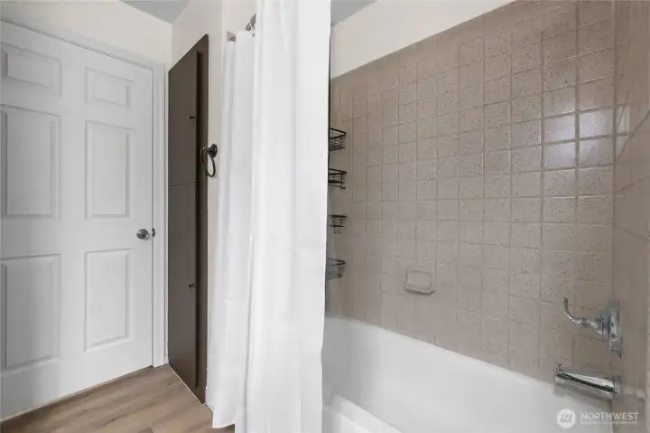 Full bath featuring tiled shower walls & new faucet.