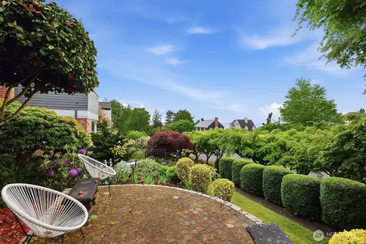 An inviting front paver patio is surrounded by manicured landscaping, drawing you in and welcoming you home.