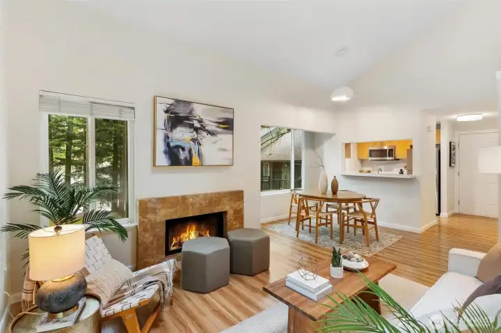 Open-concept living and dining area with a remodeled kitchen beyond. Open-concept living and dining area with a remodeled kitchen beyond.