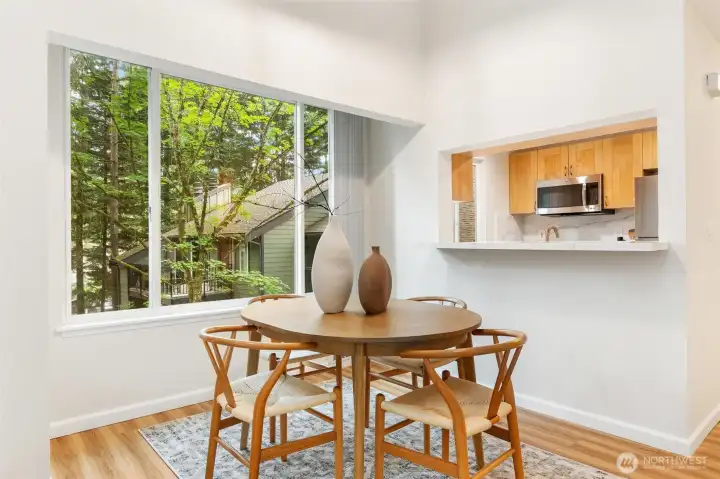 Dining area surrounded by wooded views with a breakfast bar opening to the kitchen. Dining area surrounded by wooded views with a breakfast bar opening to the kitchen.