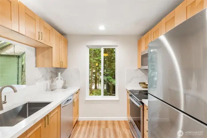 Modern galley kitchen featuring quartz countertops and stainless steel appliances. Modern galley kitchen featuring quartz countertops and stainless steel appliances.