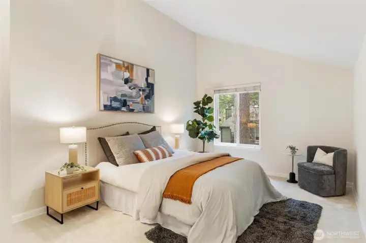Spacious main level primary bedroom with vaulted ceilings and large windows. Spacious main level primary bedroom with vaulted ceilings and large windows.