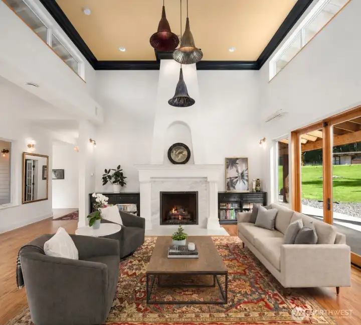 Inside, a substantial floor-to-ceiling fireplace creates a stunning focal point and dramatic statement within the main living space.