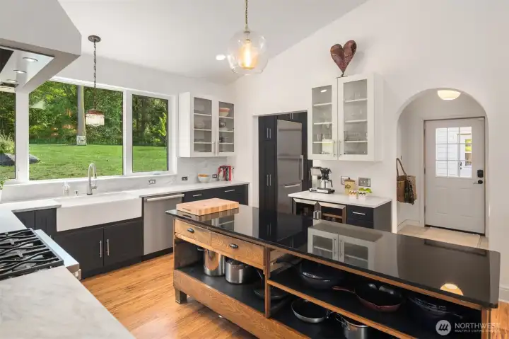 A walk-in designer pantry showcases floor-to-ceiling cabinetry with custom pull-outs for exceptional style and functionality.