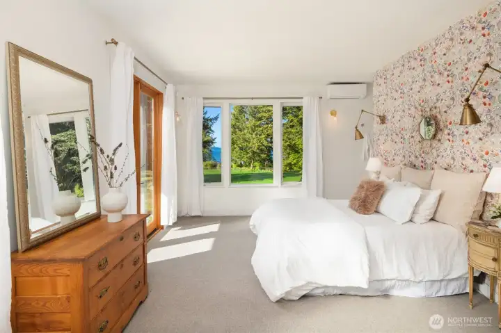 The primary suite features French doors opening to the covered patio, creating a peaceful setting to watch bunnies wander and eagles soar overhead.