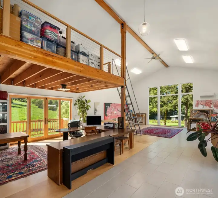 This expansive 1,159 sq ft studio is bright and fully finished, featuring 220 power, a sink, loft space, and French doors that open to the surrounding landscape.