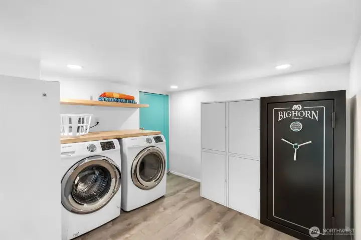 Utility room with washer, dryer, freezer and safe. Additional storage through the door behind.