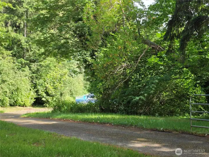Looking beyond the clubhouse, toward the outdoor pool. This vacant lot is locted just one house away from the road access to the club and pool.