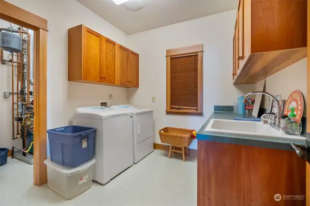 Laundry room with convenient sink and built-in cabinetry for extra storage.