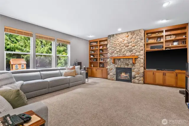 Spacious living room with gas fireplace, gorgeous built-ins and a wall of windows to let the light in