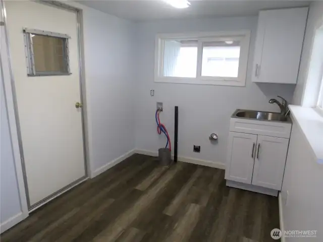 You have entered the laundry room from car port.  The door you see goes into the home.  This laundry room/mud room has enough room for more storage ideas.