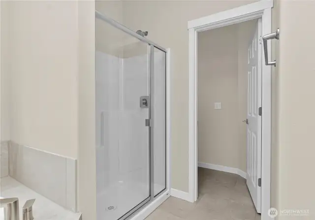 Primary bathroom offers a standard walk-in shower with glass door and a separate, private water closet.